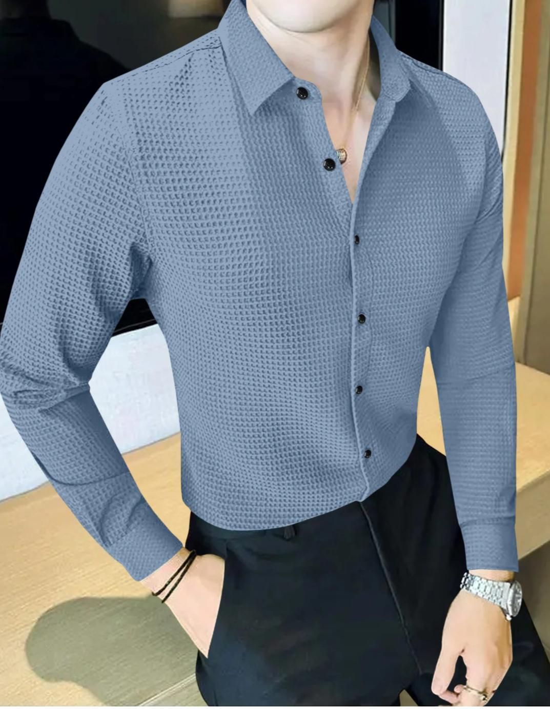Person wearing a blue textured shirt with a blurred background